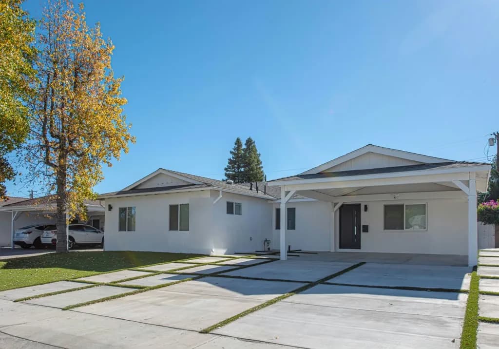 Exterior of the Kittridge project by Yeganeh Inc., showing the remodelled single-storey house with a new carport and banded hardscape