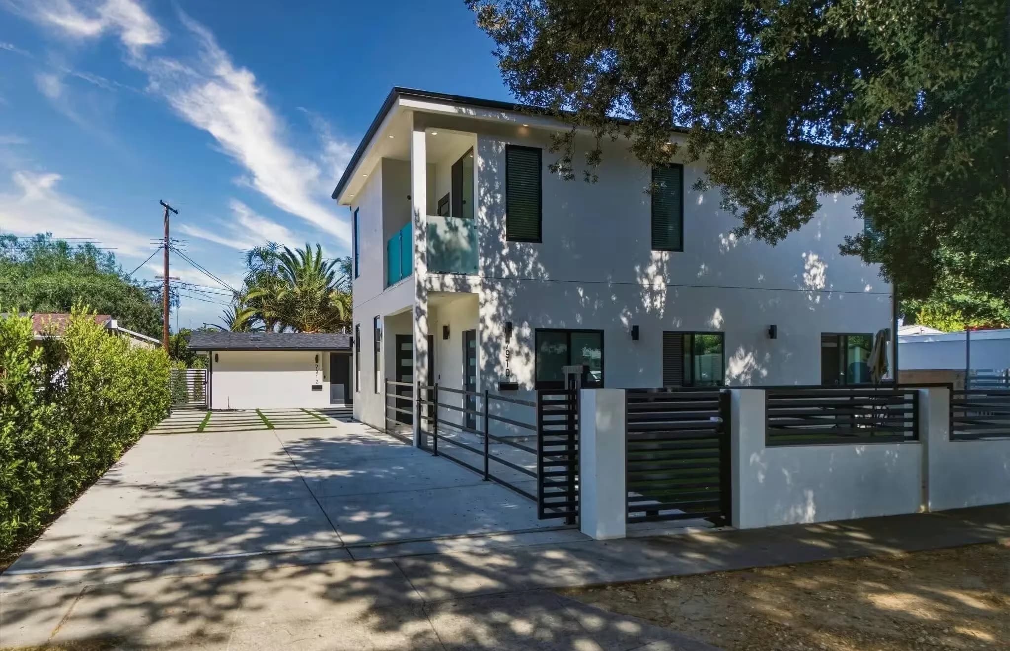 Completed two-story accessory dwelling unit built by Yeganeh Inc., with white stucco, dark window frames and a landscaped yard