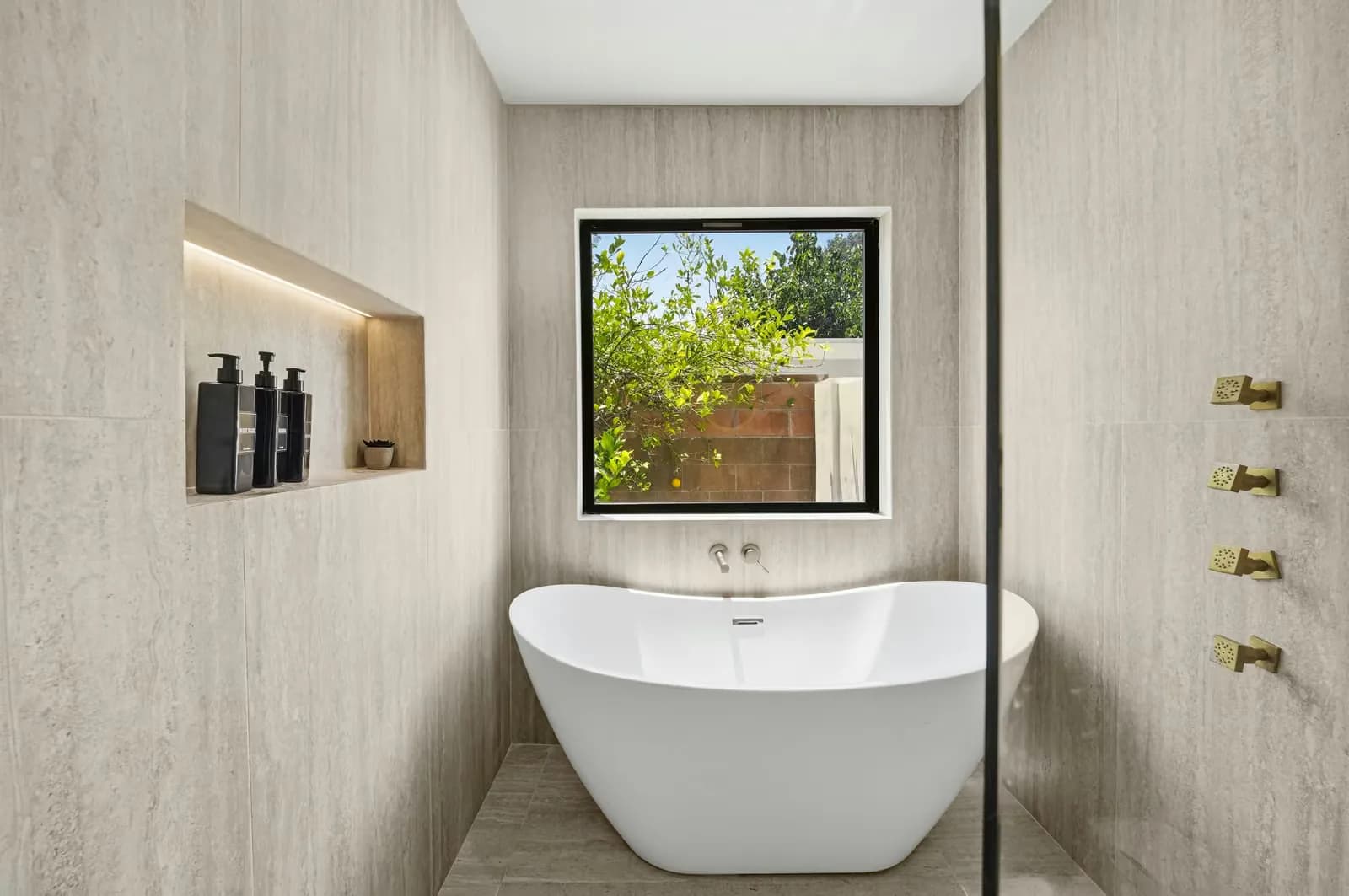 ADU bathroom with a freestanding tub, a walk-in shower and a window onto the garden