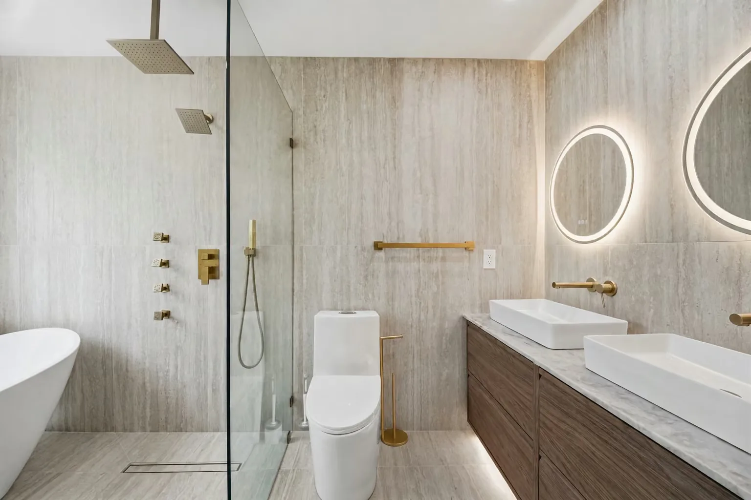 ADU bathroom with a double vanity, a lit oval mirror and a freestanding tub