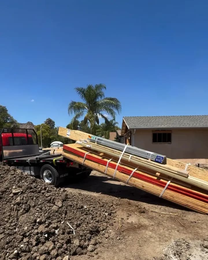 Lumber delivery being unloaded by truck at an active Yeganeh Inc. job site